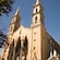 The Cathedral Basilica of the Immaculate Conception flanked by statues, trees and a fence